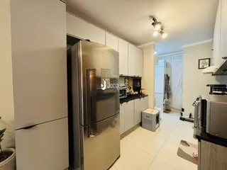 Foto de uma cozinha moderna com armários brancos e eletrodomésticos de aço inoxidável.