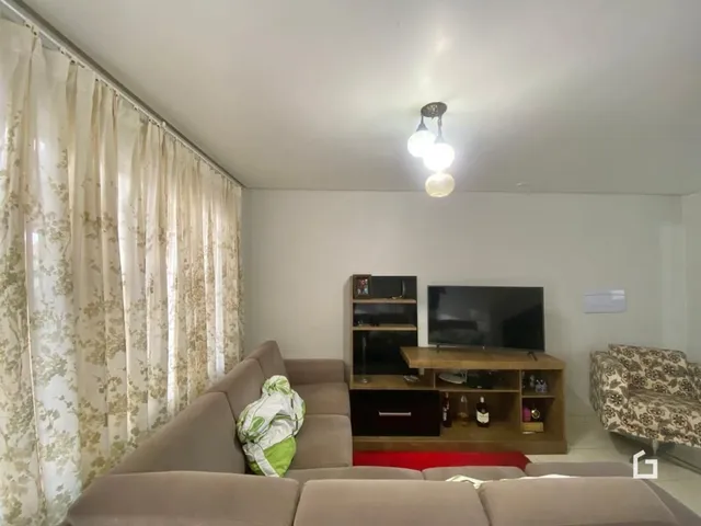Sala de estar com sofá e móveis em um imóvel.