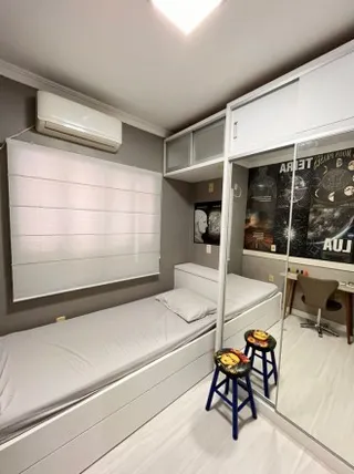 Quarto com cama e armários brancos modernos.