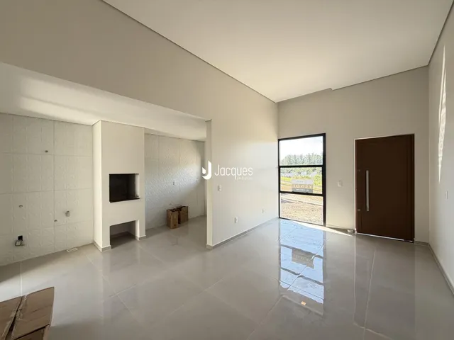 Vista interna de uma sala ampla com piso de cerâmica clara.