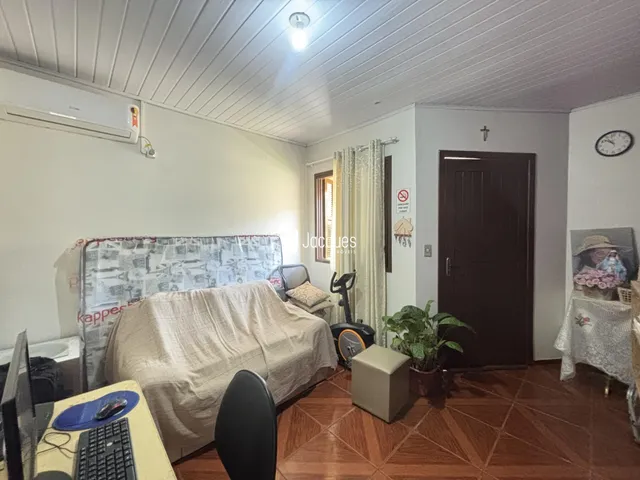 Quarto com piso de madeira e parede branca em imóvel no Brasil.