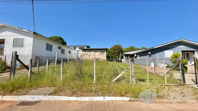 Fachada de uma propriedade com cerca e vegetação no quintal.