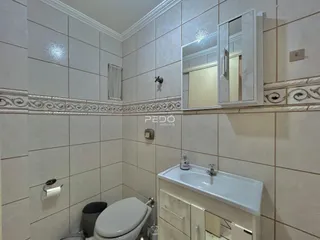 Foto de um banheiro com revestimento de azulejos brancos e pia.