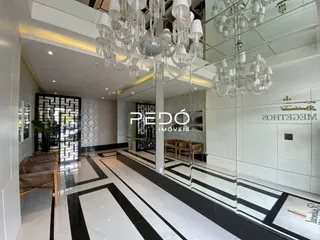 Hall de entrada com piso preto e branco e espelhos.