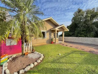 Fachada de uma casa em Lajeado, Brasil com jardim gramado e palmeira.