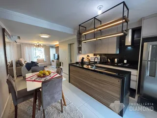 Ambiente de sala de estar e cozinha de um apartamento moderno.