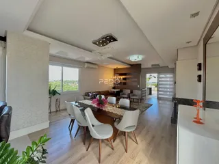Sala de jantar e estar com piso de madeira clara em um imóvel em Lajeado.