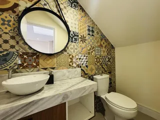 Foto de um banheiro com revestimento de azulejos e bancada de mármore.