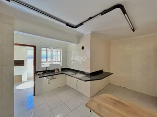 Foto de uma cozinha com revestimento cerâmico nas paredes e piso.