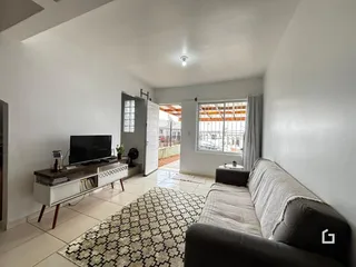 Sala de estar com sofá e televisão em um apartamento.