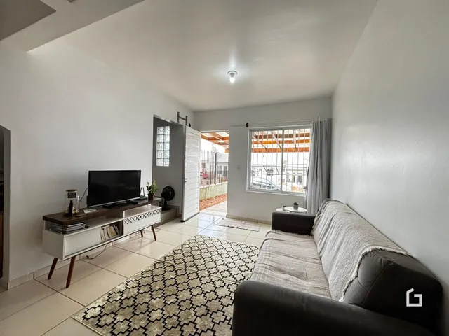 Sala de estar com sofá e televisão em um apartamento.