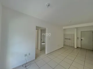 Interior de um corredor com piso de cerâmica claro.