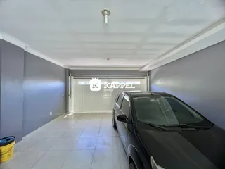 Hall de entrada com piso de cerâmica e acesso à garagem.
