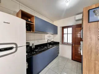 Vista da cozinha moderna com armários azuis e bancada escura.