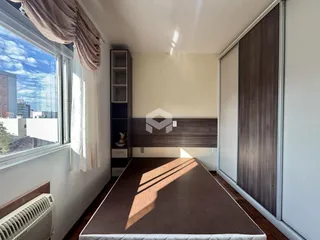 Quarto com janela e armários em madeira.