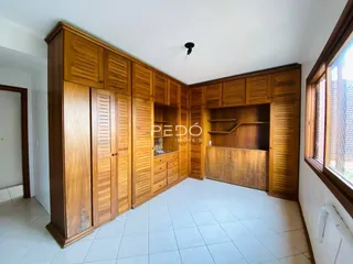 Foto de um ambiente interno com armários de madeira e piso cerâmico.