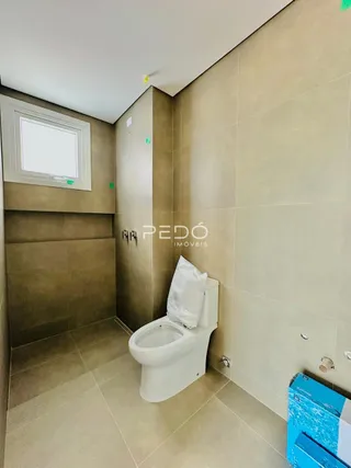 Foto de um banheiro interno com piso de cerâmica e vaso sanitário branco.