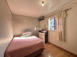 Foto de um quarto com cama e janela em uma residência.