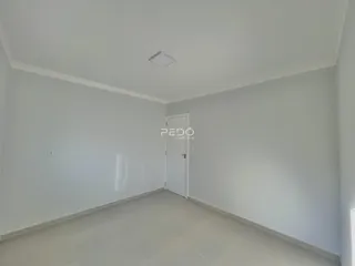 Ambiente interno de uma sala ou corredor com piso claro e paredes brancas.