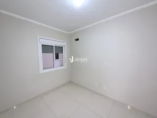 Foto de um cômodo interno com paredes brancas e piso de cerâmica.