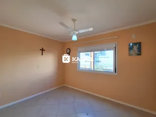 Sala de estar ampla com paredes em tom bege e piso de cerâmica.