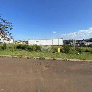 Vista da propriedade com vegetação e estrutura no fundo.