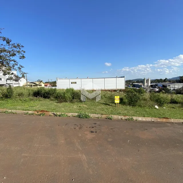 Vista da propriedade com vegetação e estrutura no fundo.