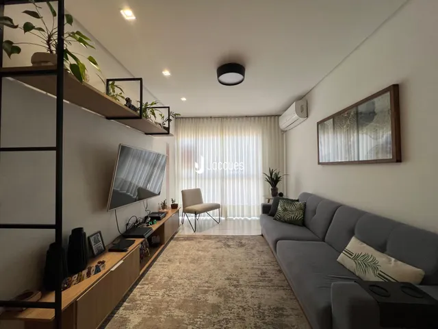Sala de estar com sofá cinza e decoração moderna em um imóvel no Brasil.