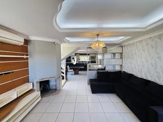Sala de estar com piso de cerâmica clara e detalhes arquitetônicos.