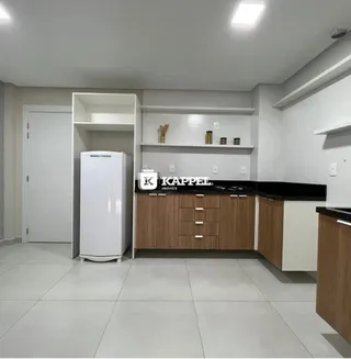 Cozinha moderna com armários brancos e bancada escura.