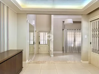 Hall de entrada com piso claro e paredes neutras em uma residência.