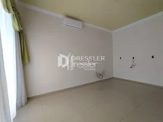 Vista interna de um ambiente com paredes brancas e piso claro.