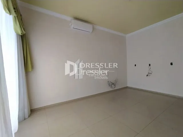 Vista interna de um ambiente com paredes brancas e piso claro.