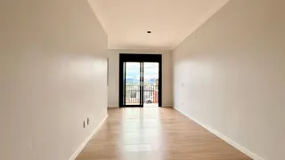 Interior de um ambiente com piso de madeira clara e paredes brancas.