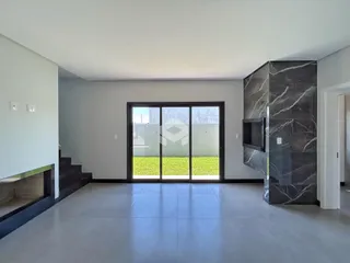 Sala de estar com porta de vidro abrindo para o jardim.