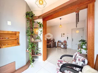 Interior de uma sala com vigas de madeira e plantas pendentes.