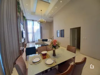 Sala de jantar iluminada com mesa de jantar e janelas amplas.