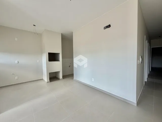 Ambiente interno de uma sala ampla com piso de cerâmica clara.
