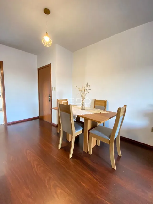 Ambiente interno com piso de madeira e mesa de jantar.