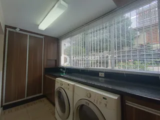 Vista interna de uma cozinha com armários e máquinas de lavar roupa.