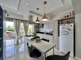 Interior de uma cozinha moderna com ilha e grandes janelas em Lajeado.