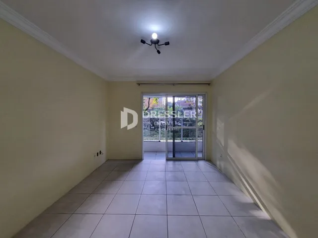 Corredor interno com piso de cerâmica e paredes claras.