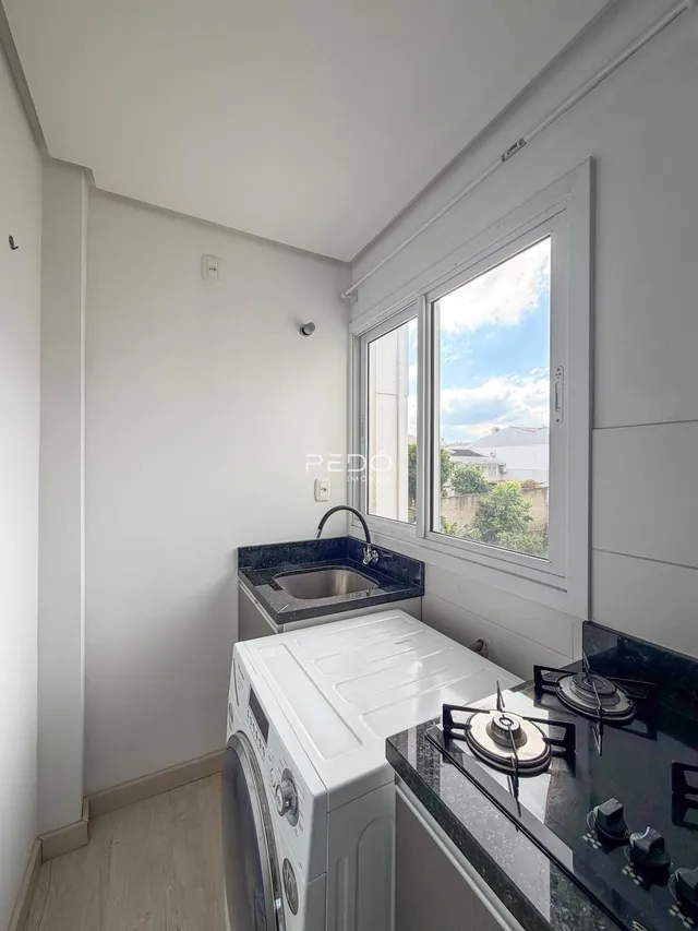 Foto de uma cozinha moderna com bancada escura e eletrodomésticos brancos.