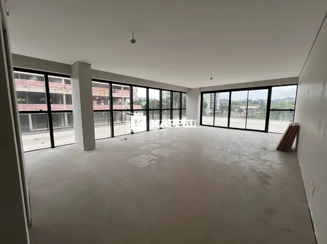 Espaço interno amplo com grandes janelas de vidro.