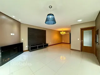 Sala de estar com piso de cerâmica claro e parede de destaque escura.