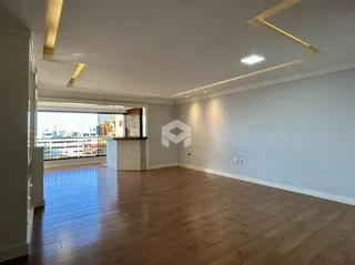 Interior de uma sala com piso de madeira e vista para a varanda.