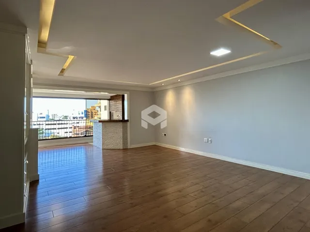 Interior de uma sala com piso de madeira e vista para a varanda.