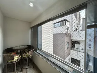 Vista interna de uma sala de jantar com mesa e cadeiras.