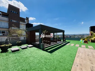 Área externa com gramado e pérgola em um imóvel.