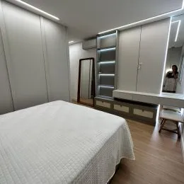 Foto de um quarto com cama e armários brancos.